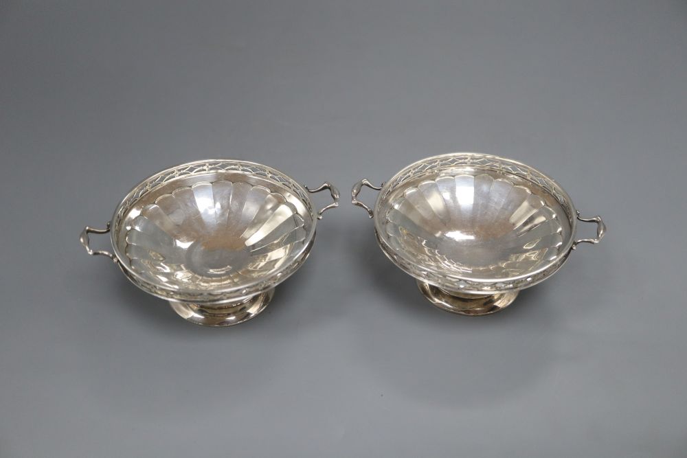 A pair of silver two handled bon bon dishes, with pierced gallery on circular bases, Birmingham 1925, 5.1oz. gross, width 11cm